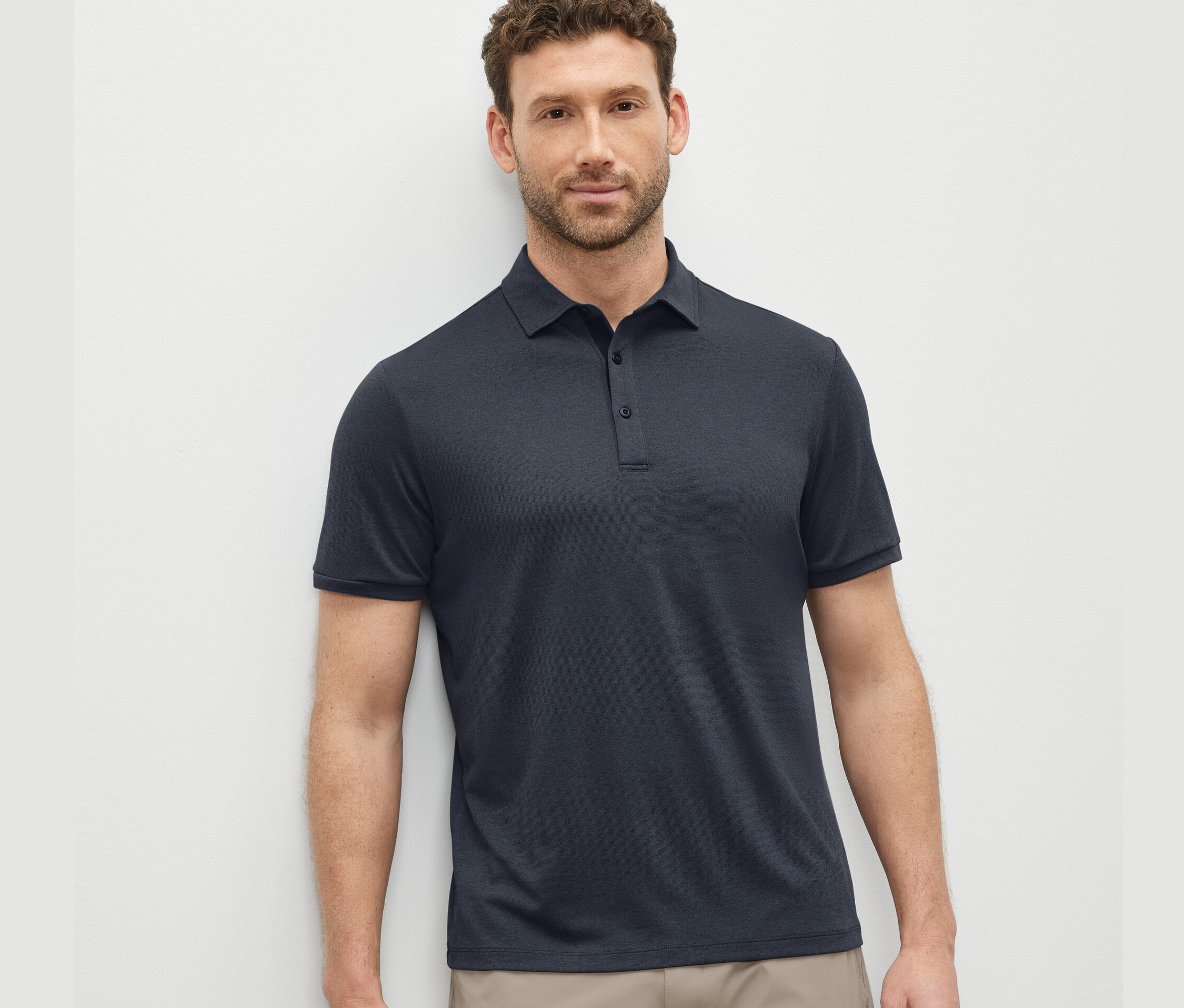 Mężczyzna ma na sobie granatową funkcyjną koszulkę polo.