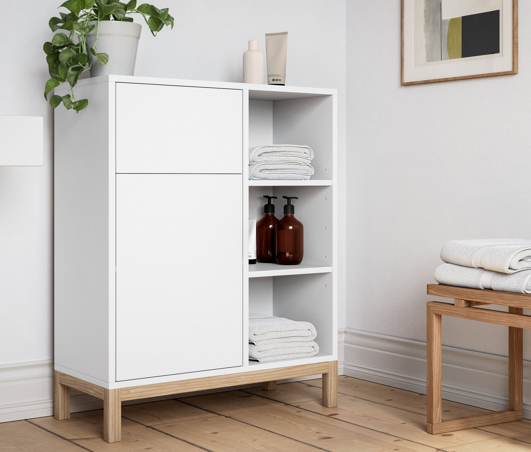 W łazience stoi biała szafka łazienkowa i ławka do siedzenia.