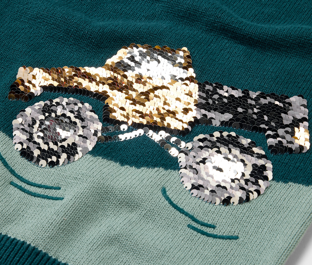 Zbliżenie na dzianinowy sweter dziecięcy z motywem błyszczącej ciężarówki.