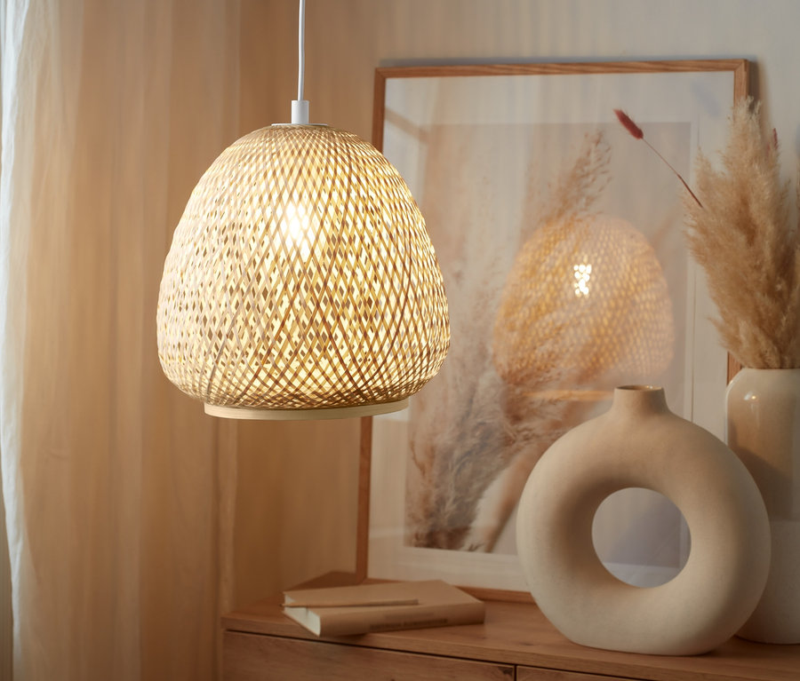 Lampa wisząca nad drewnianą komodą.