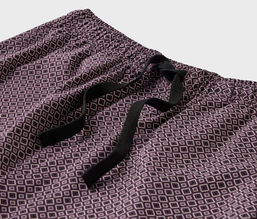 Zbliżenie fioletowych spodni od piżamy we wzory ze sznurkiem.