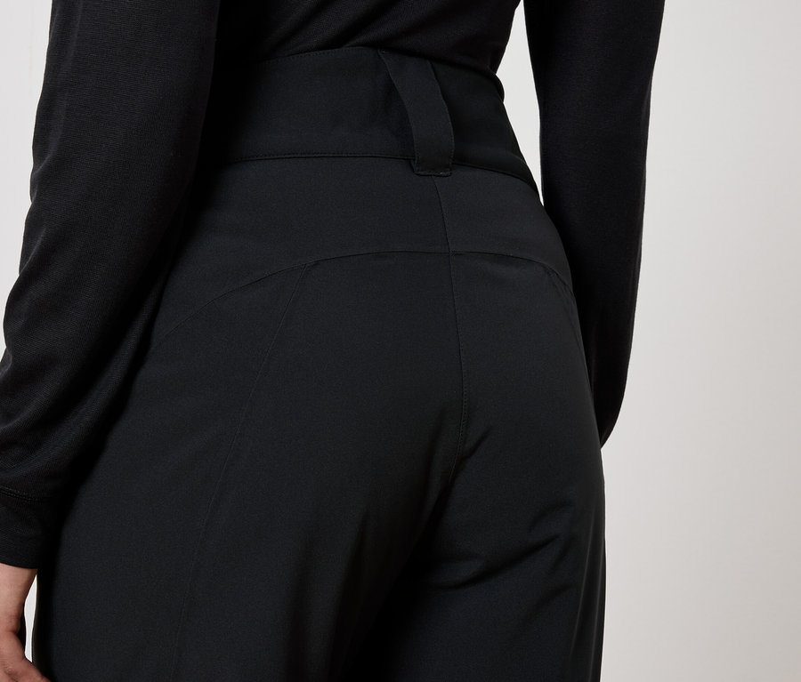 Widok z tyłu kobiety w czarnych spodniach i czarnym topie.