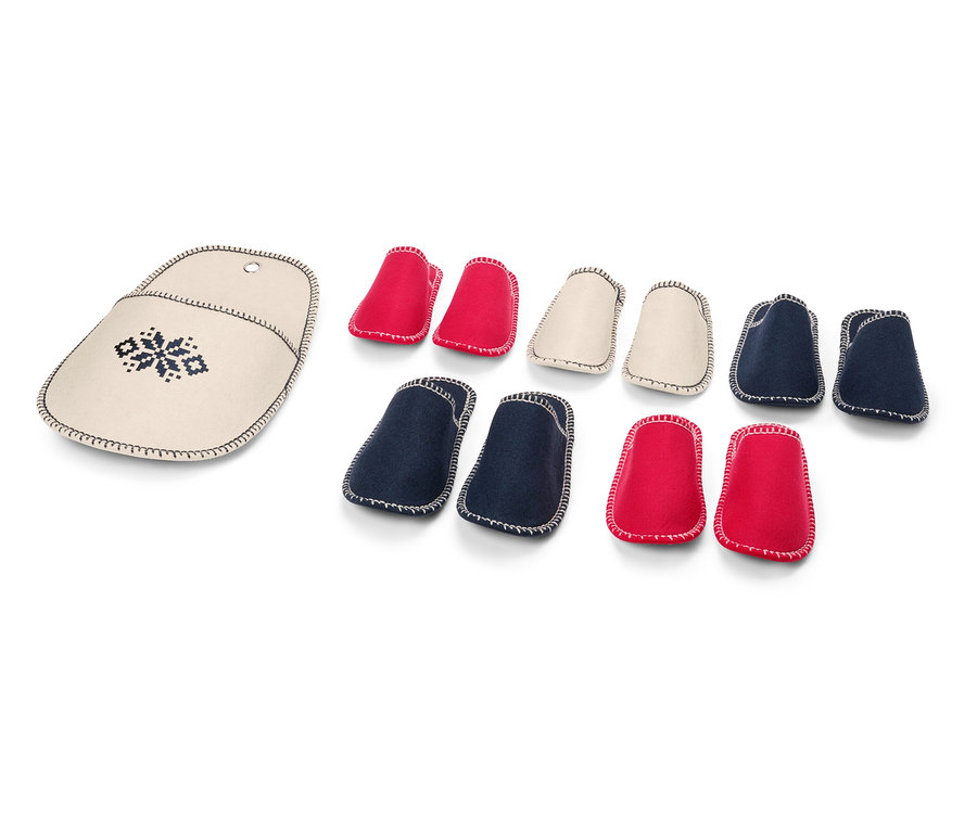 Etui na druty z haftem obok zestawu czerwonych, kremowych i niebieskich osłonek na końcówki drutów.