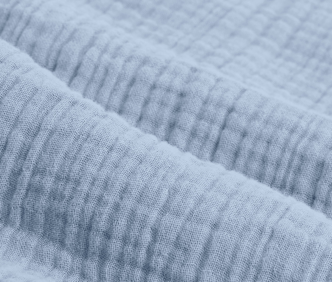 Zbliżenie na jasnoniebieską pościel muślinową w standardowym rozmiarze.