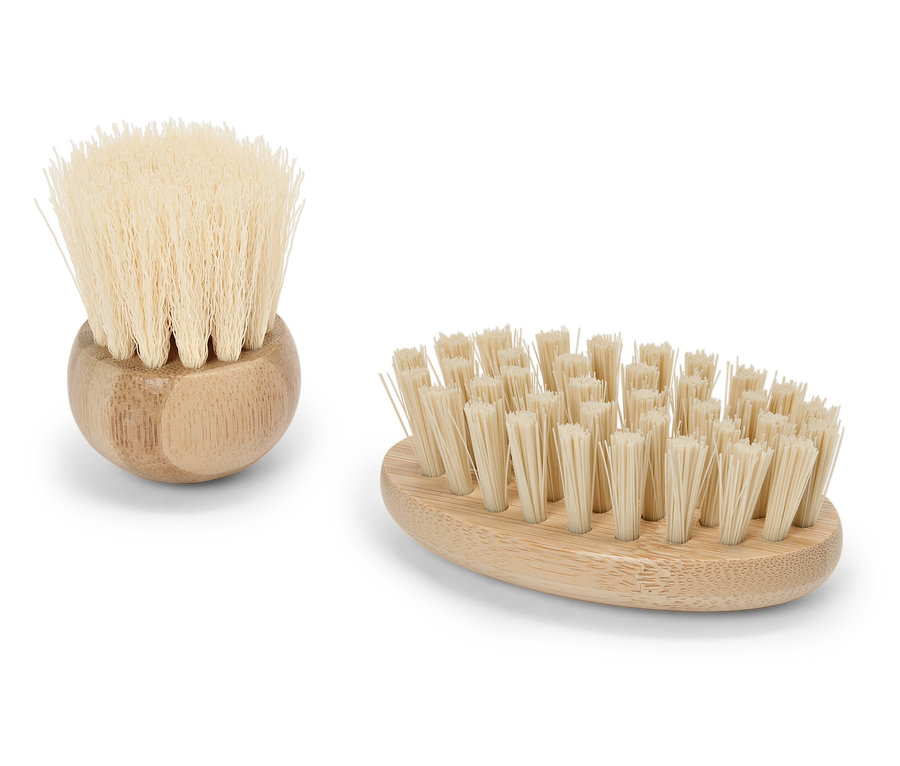 Dwie drewniane szczotki z naturalnym włosiem leżą na białym tle.