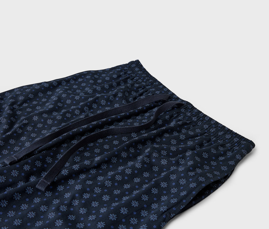 Zbliżenie granatowych spodni od piżamy ze sznurkiem w pasie.