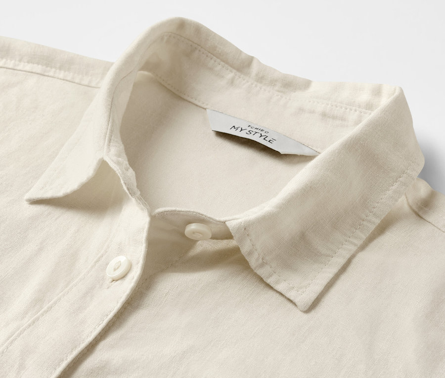 Szczegół kremowej, lnianej bluzki.