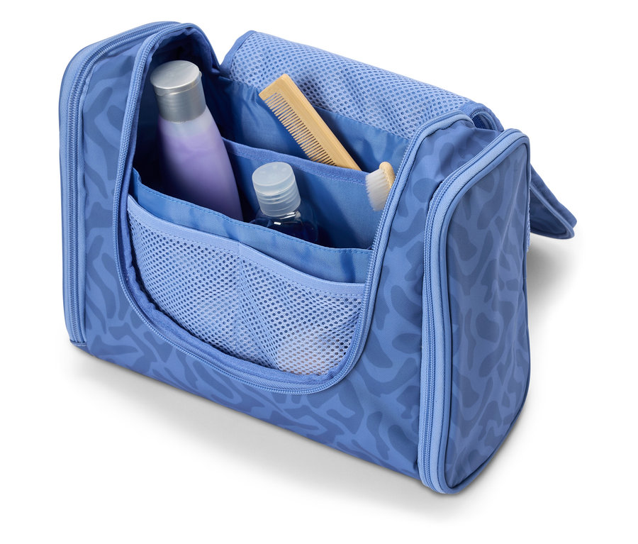 Otwarta, jasnoniebieska kosmetyczka z różnymi przyborami podróżnymi, takimi jak szampon, grzebień i szczoteczka do zębów.