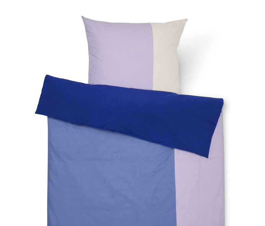 Komplet pościeli z niebieskim poszewką i liliową oraz kremową poszewką na poduszkę.