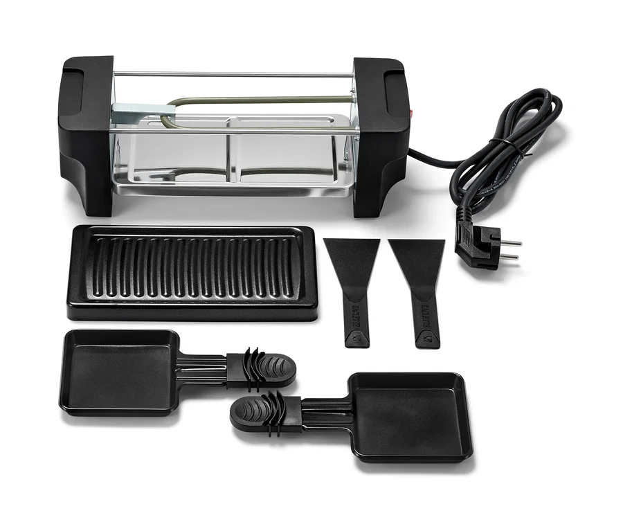 Raclette dla dwóch osób z grillem, patelniami i skrobakami.