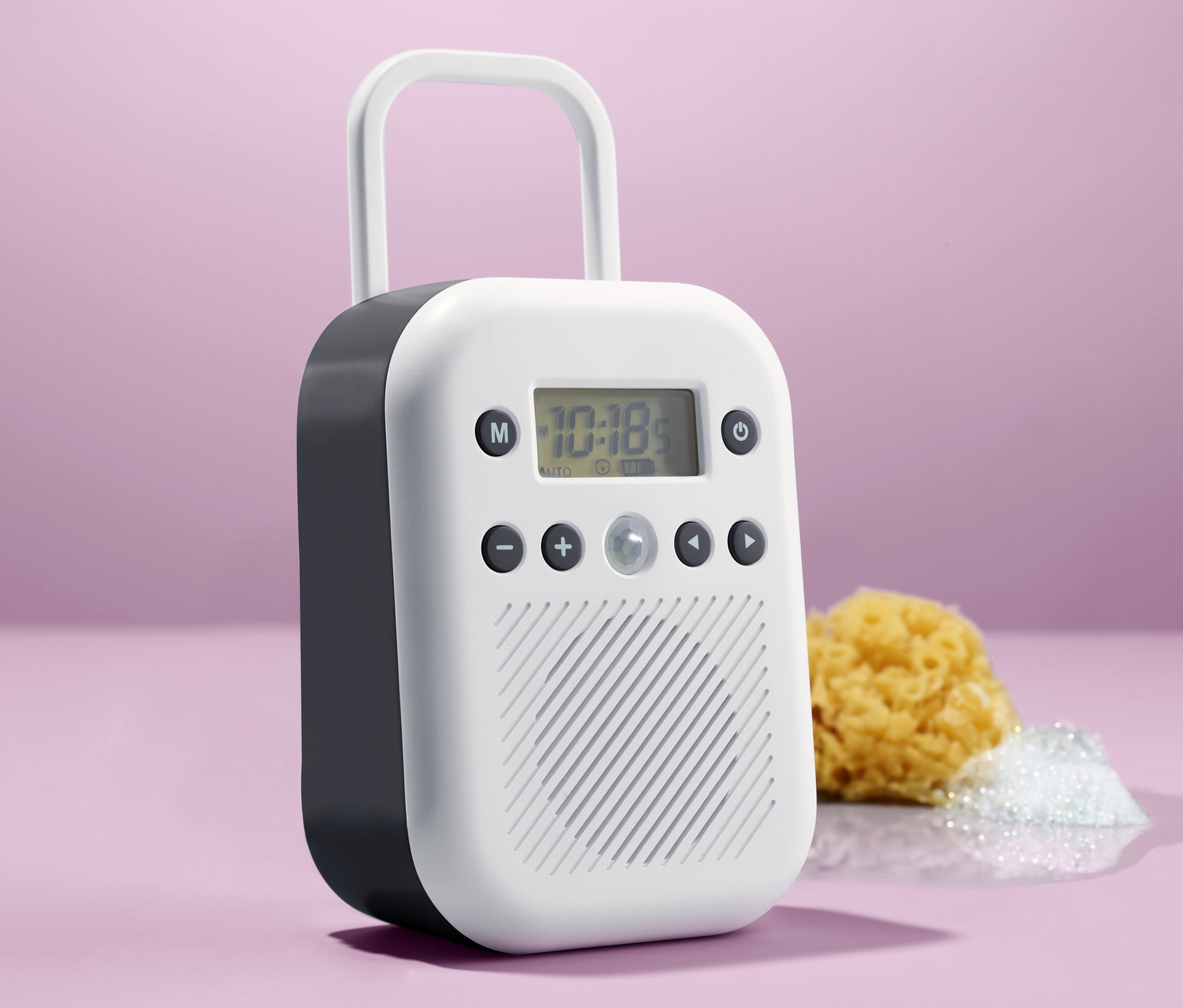 Białe radio łazienkowe stoi obok żółtej myjki i kupki białej piany.