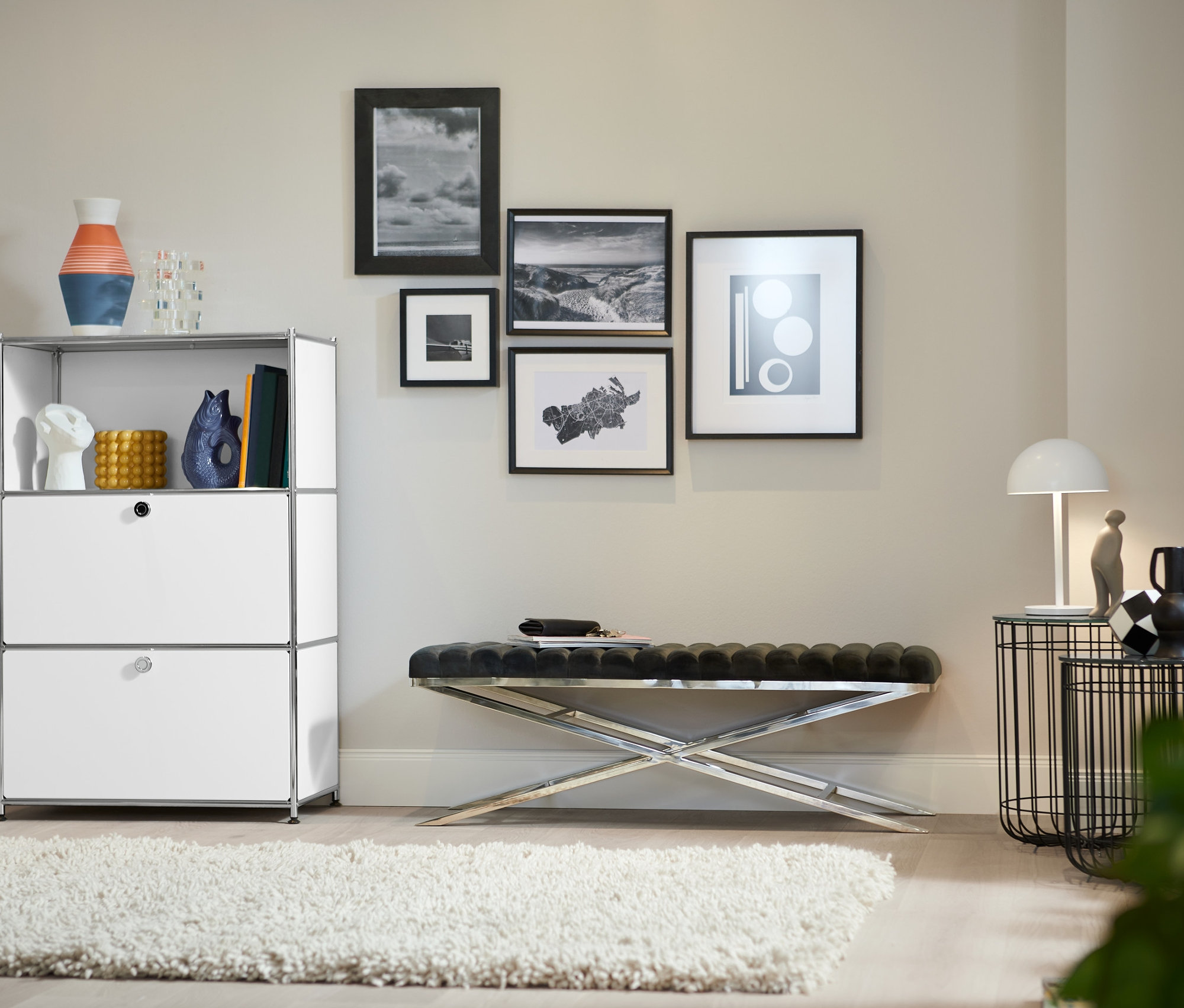 Salon z metalową szafką z 2 białymi klapami, ławką z metalowym stelażem i metalowym wózkiem barowym.