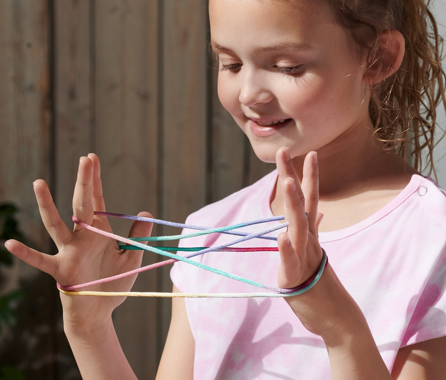 Dziewczyna gra w Fingertwist, mając sznurek między palcami.
