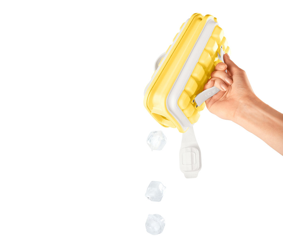Ręka trzyma żółtą kostkarkę do lodu »ICEBREAKER® POP« i wysypuje kostki lodu.