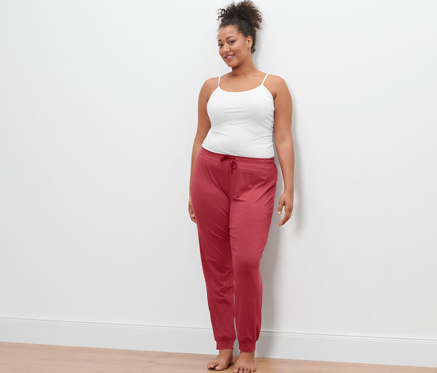 Kobieta ma na sobie białe podkoszulki i spodnie od piżamy.