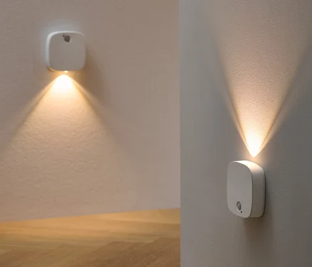 Dwie wielofunkcyjne lampki LED zamontowane na ścianie oświetlają pokój.