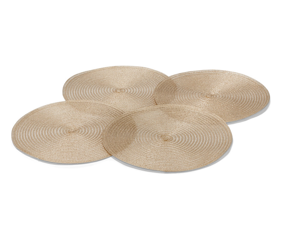 Cztery złote, okrągłe podkładki pod talerze.