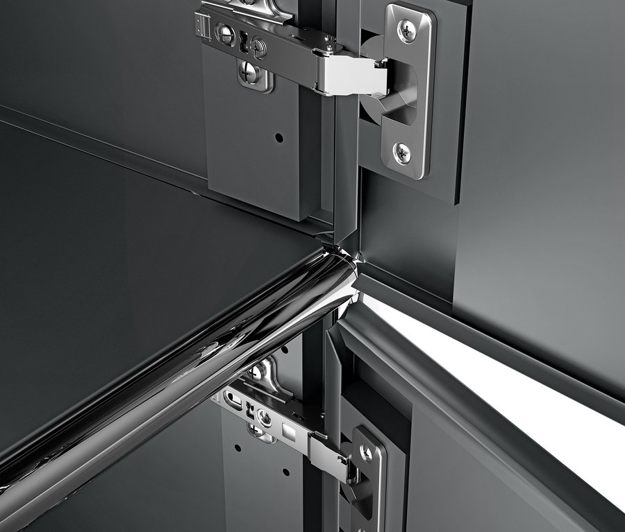 Szczegół szarego metalowego kontenera na kółkach »CN3« z 3 drzwiczkami i chromowanymi zawiasami.