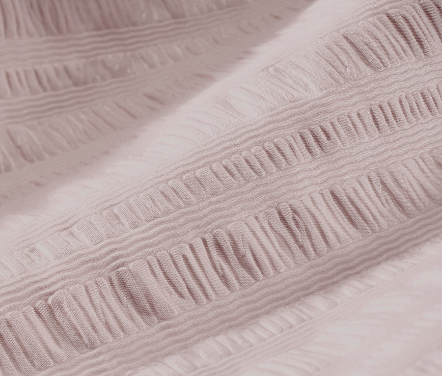 Zbliżenie na bladoróżową pościel z kory.