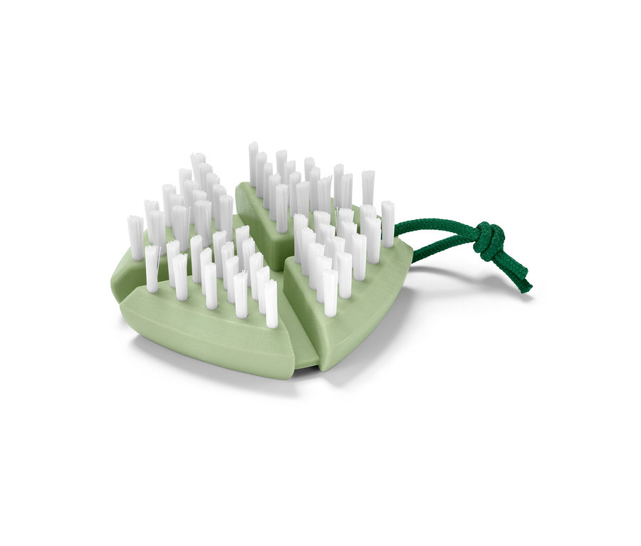 Zielona giętka szczotka do warzyw i owoców z białym włosiem i zielonym sznurkiem.