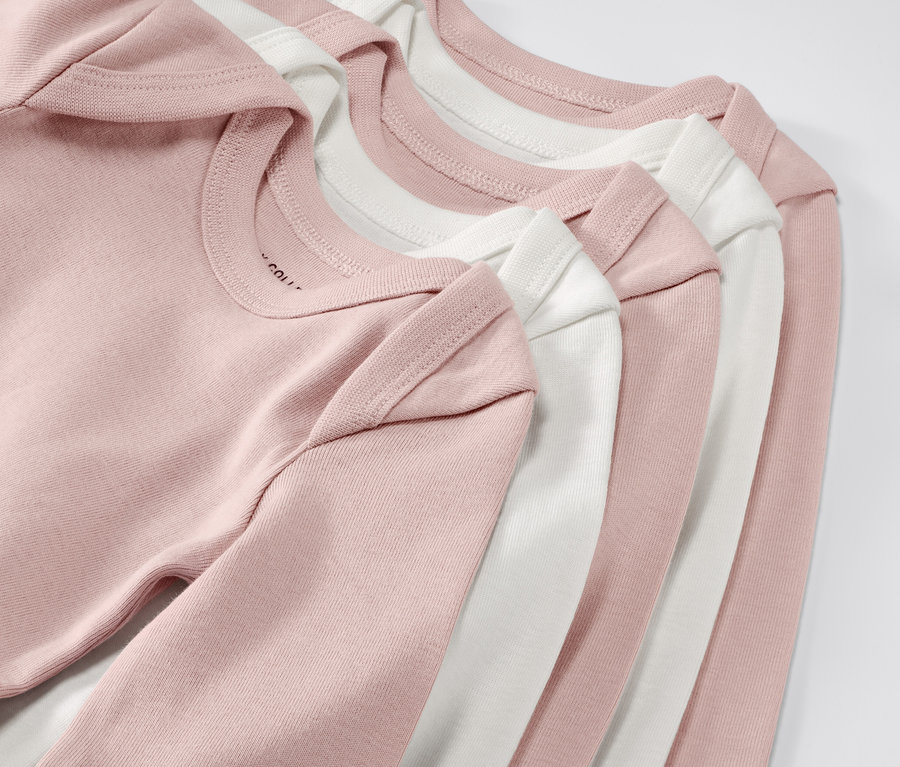 Zbliżenie na pięć różowych i białych body niemowlęcych rosnących z dzieckiem. Body niemowlęce rosnące z dzieckiem, 5 par, różowe.