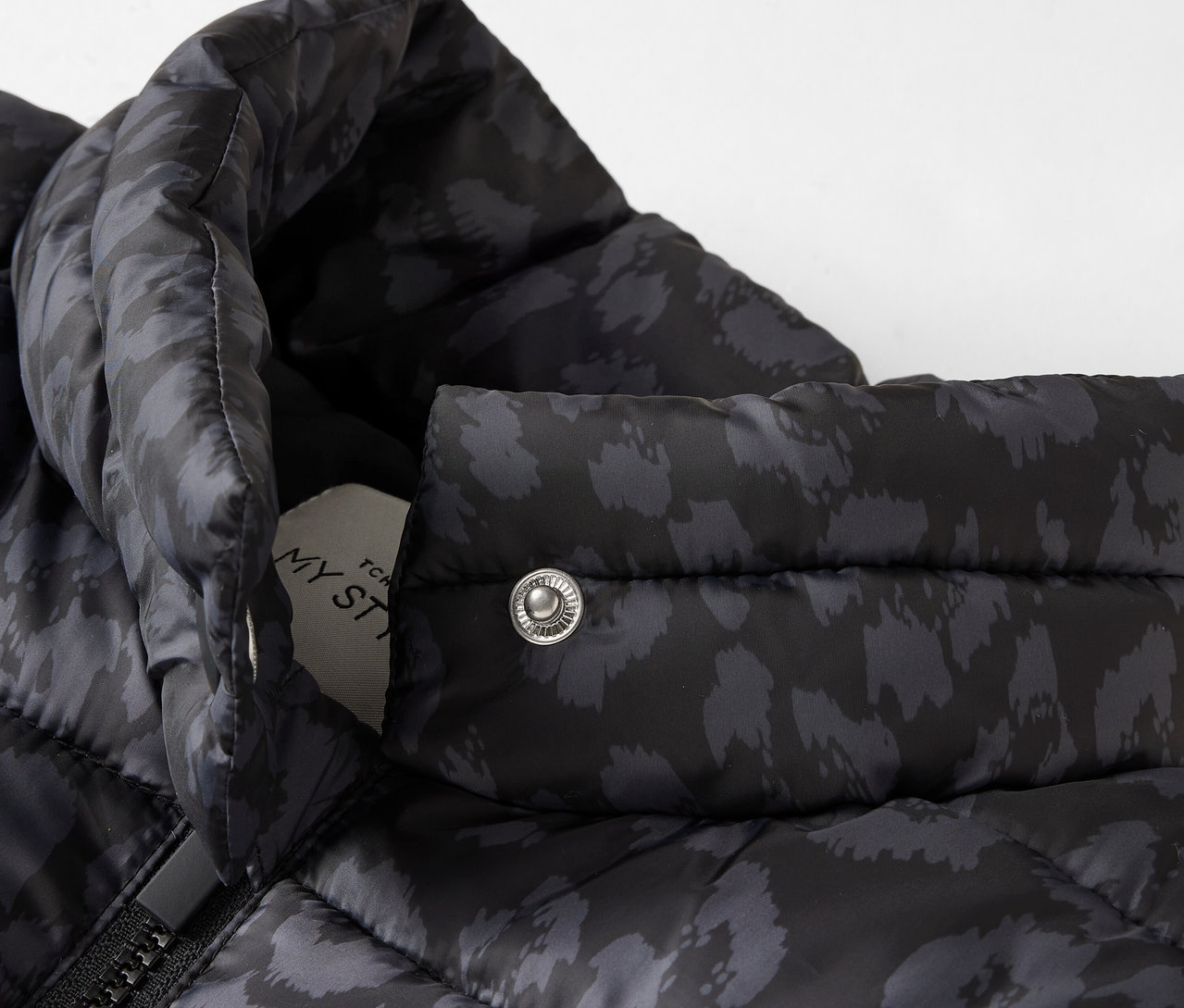 Zbliżenie na czarną, pikowaną kurtkę we wzory.