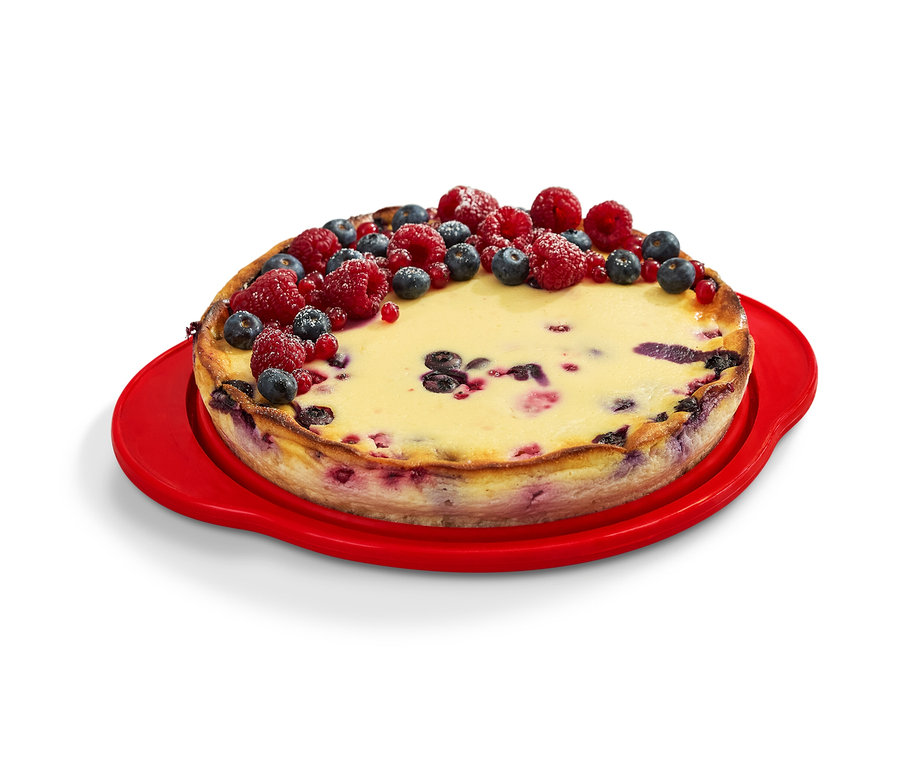 Ciasto udekorowane owocami na czerwonej składanej formie do ciast.