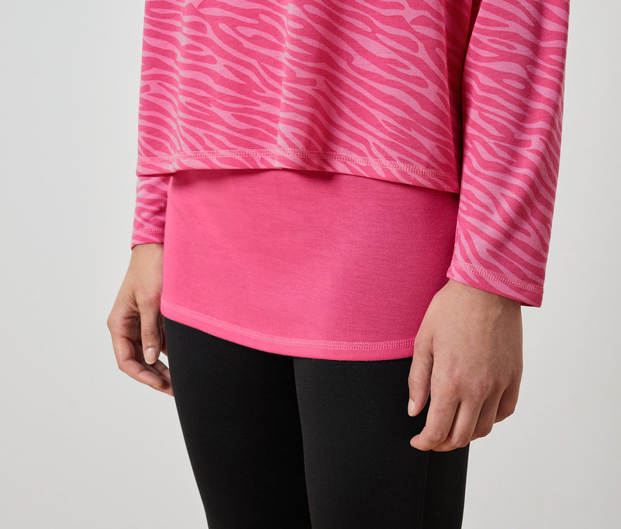 Zbliżenie kobiety w różowym topie we wzór zwierzęcy i czarnych legginsach.