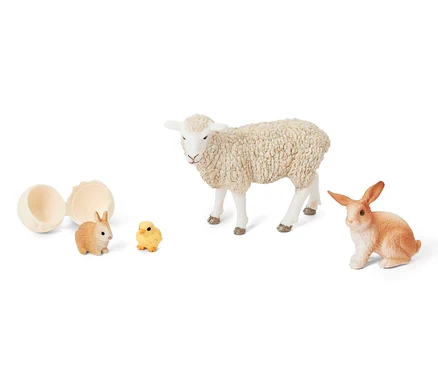Otwarte jajko obok zestawu Schleich® „Wielkanocne zwierzątka”, który zawiera jagnię, królika i kurczaka.