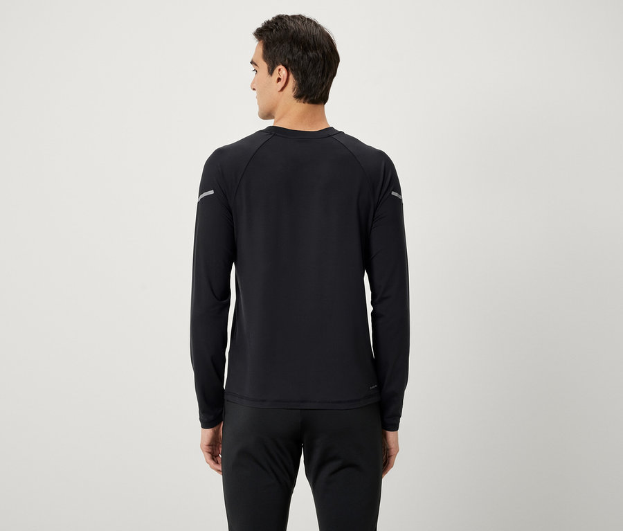 Mężczyzna tyłem do kamery ubrany w czarną koszulkę z długim rękawem i czarne spodnie dresowe.