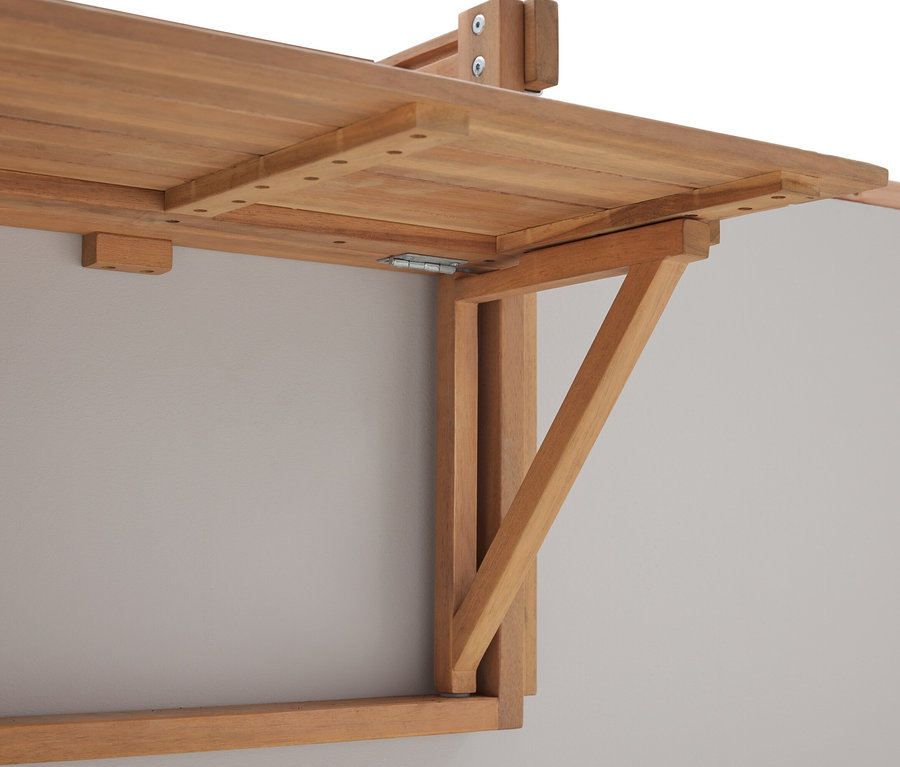 Zbliżenie rozkładanego drewnianego stołu zamontowanego na szarej ścianie.