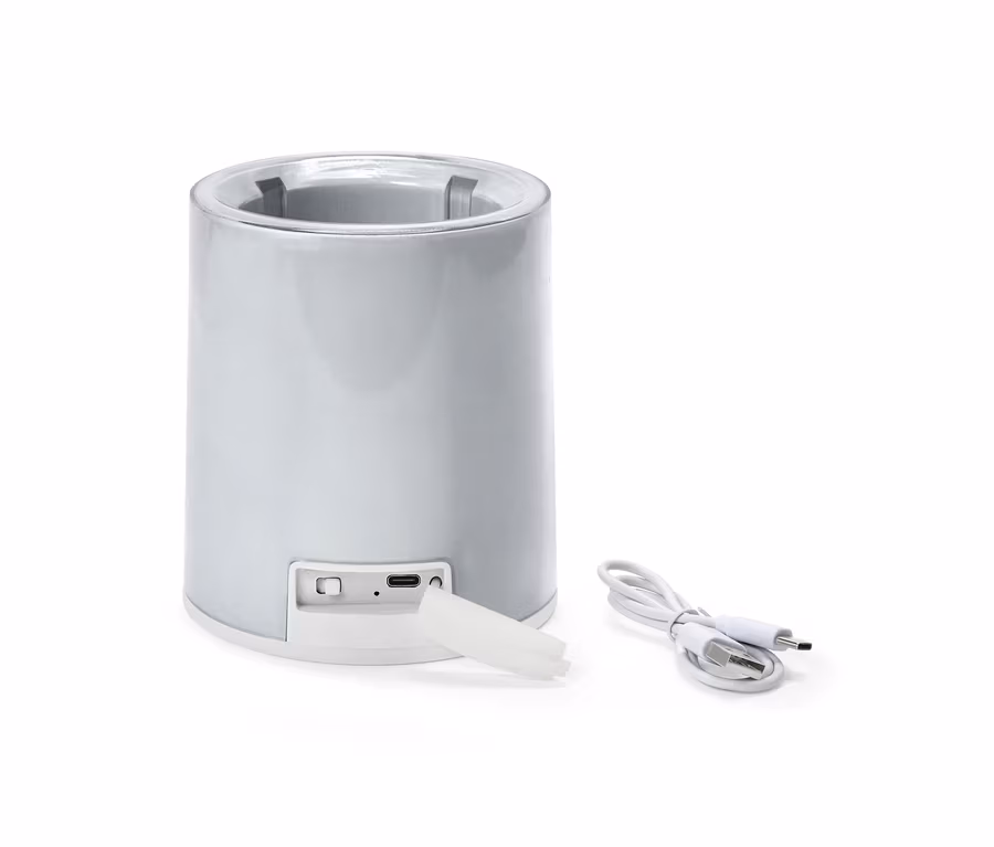 Srebrny, cylindryczny schładzacz do butelek z kablem USB i białą zatyczką na białym tle.