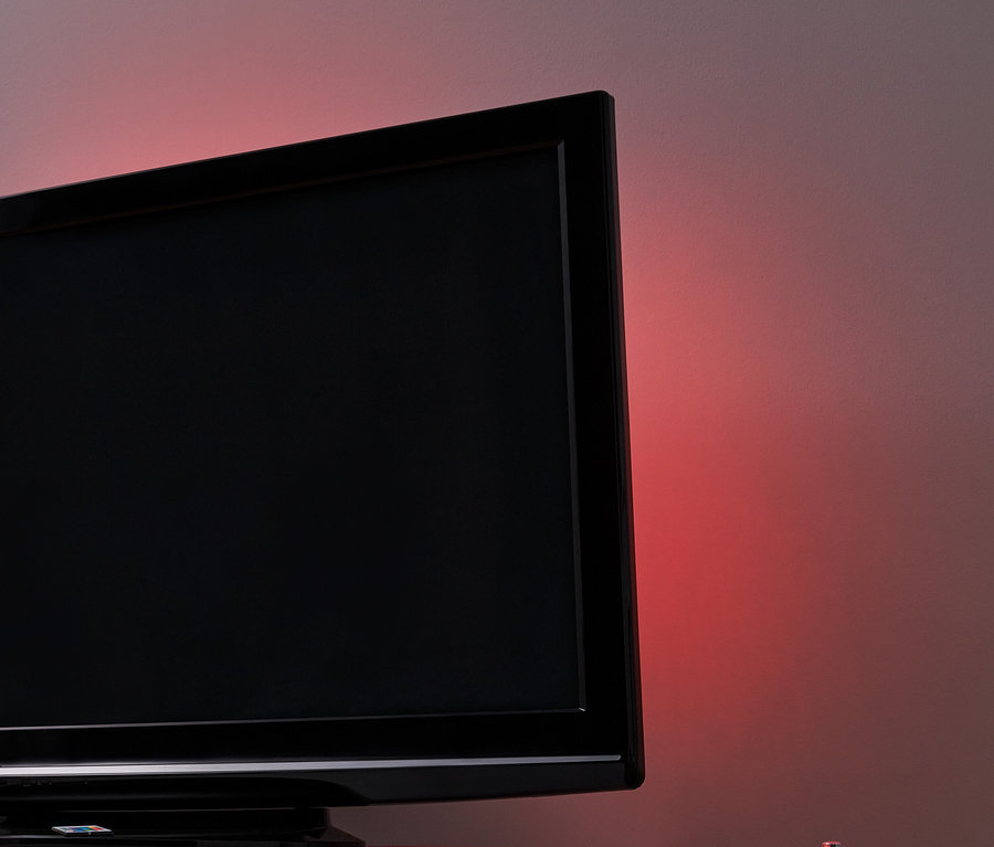 Czarny telewizor z podświetleniem LED do telewizora na białym stole.