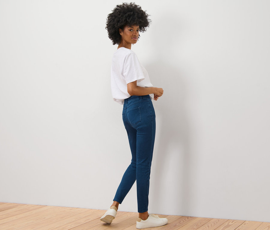 Kobieta spogląda przez ramię i pozuje w jegginsach.