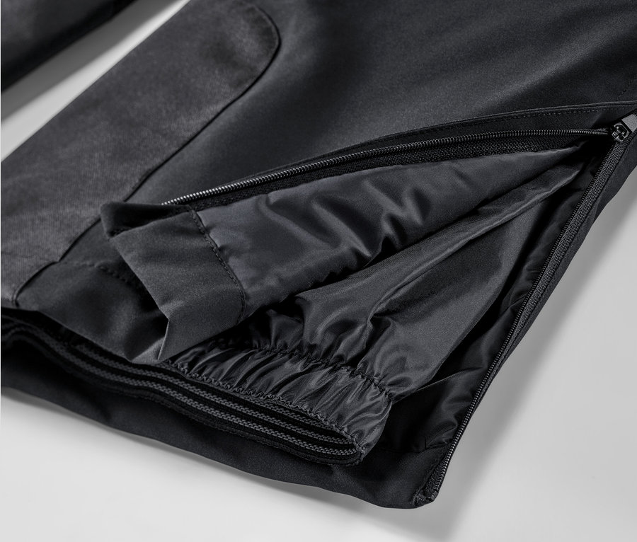 Zbliżenie czarnych spodni narciarskich z zamkiem błyskawicznym.