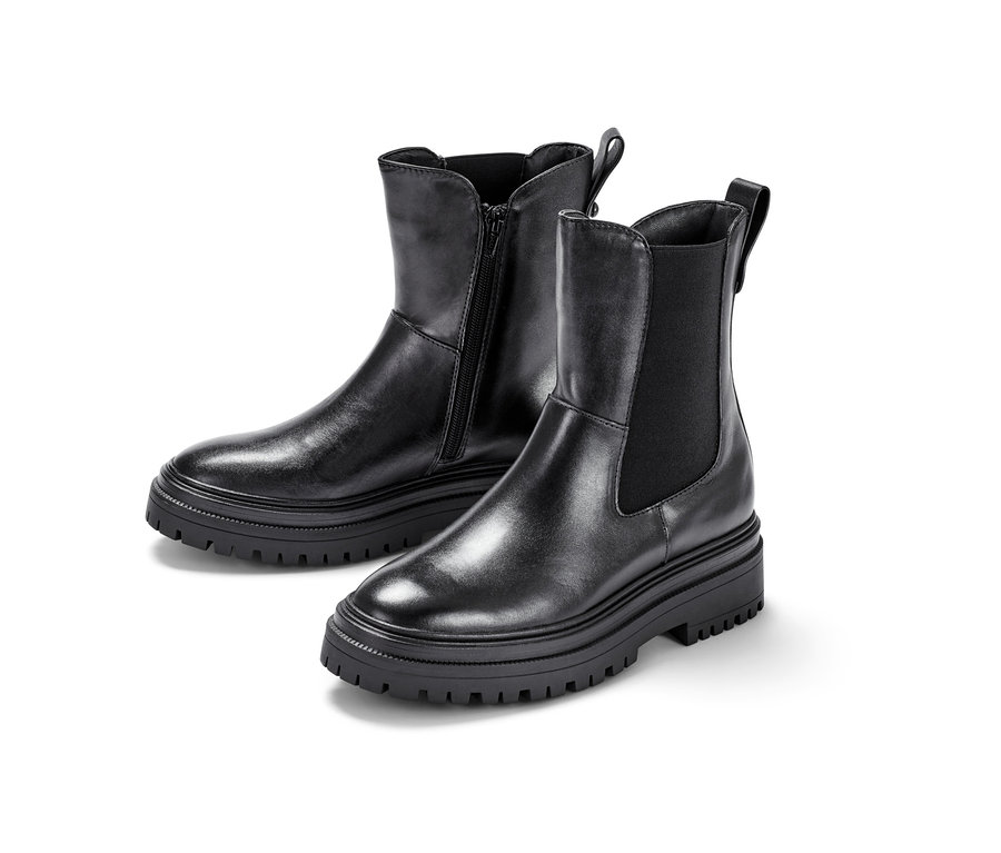 Dwa czarne botki skórzane na grubej podeszwie.