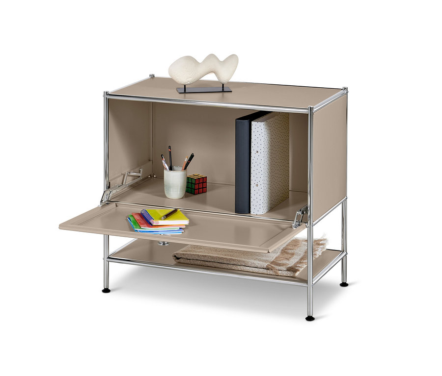 Szarobeżowa metalowa szafka typu sideboard „CN3” z klapą, na której leżą notatniki i przybory do pisania.