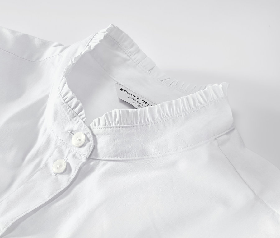 Zbliżenie na białą bluzkę z falbankami.