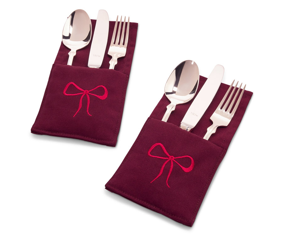 Dwa zestawy sztućców w bordowych etui z tkaniny z haftem czerwonej kokardy.