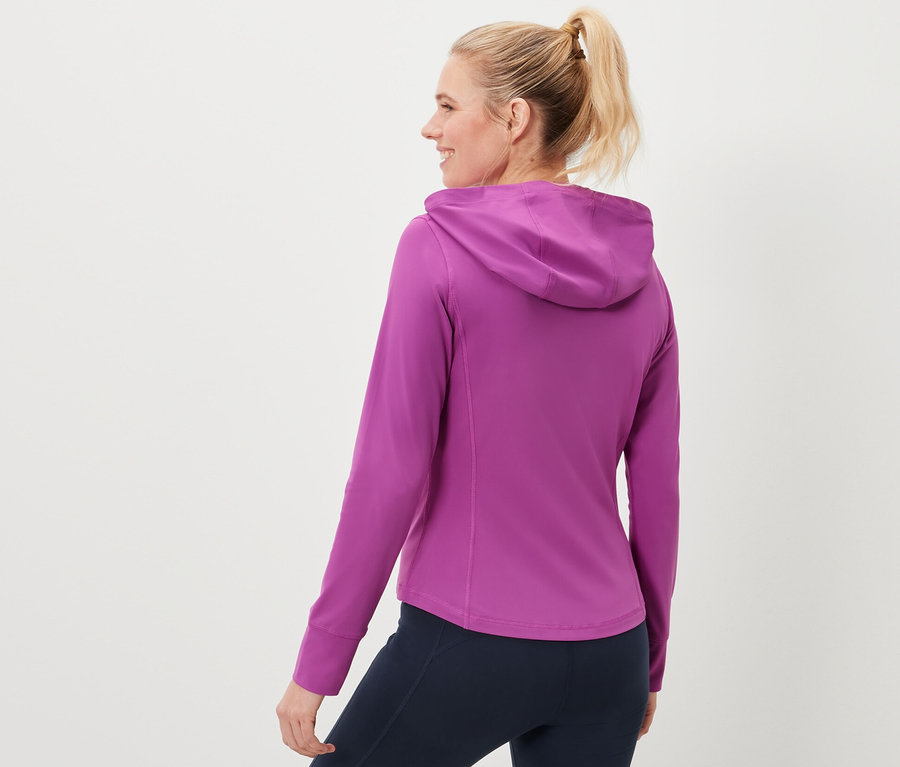 Kobieta ma na sobie bluzę sportową i granatowe legginsy.