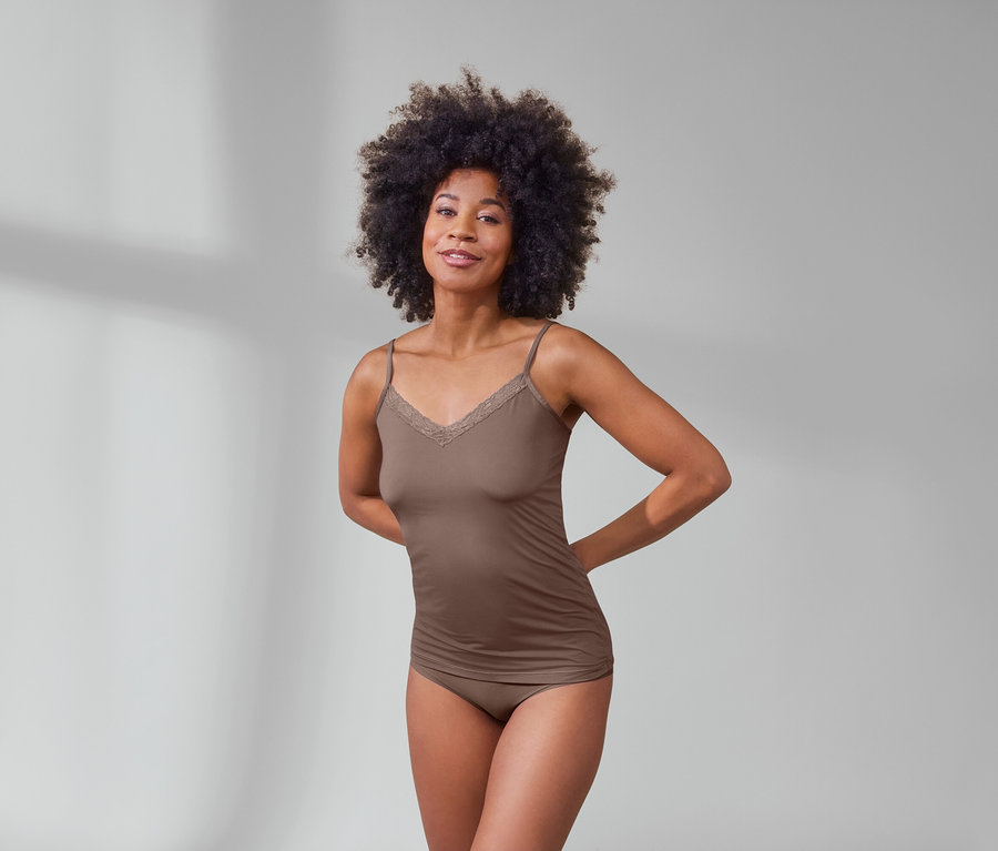 Afroamerykanka pozuje w brązowej koszulce i beżowych figach magic cut, 5 par.