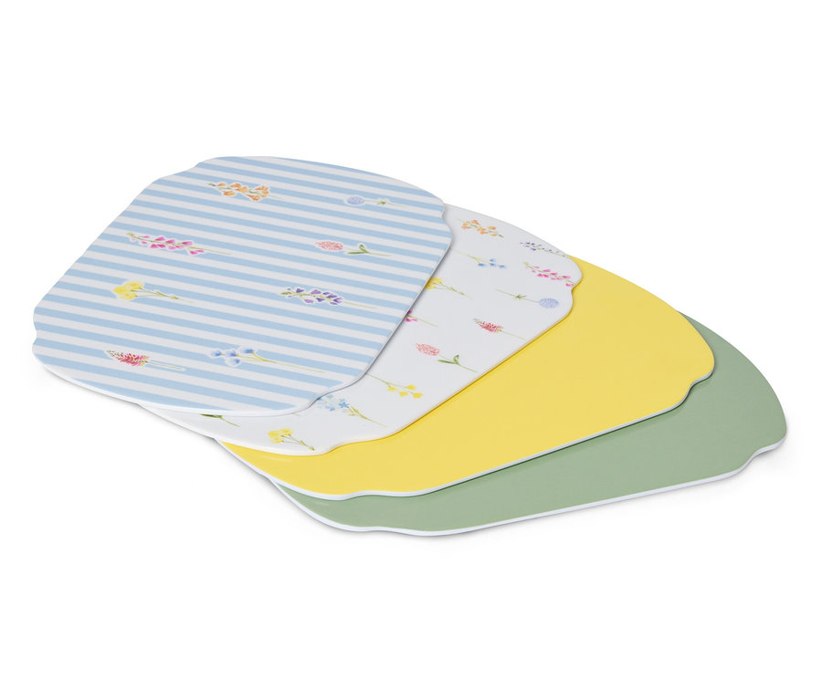 Kilka podkładek na stół leży jedna na drugiej, w tym jedna w niebiesko-białe paski, jedna biała we wzory kwiatowe, jedna żółta i jedna zielona.