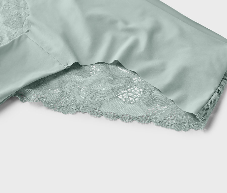 Zbliżenie miętowo-zielonej bielizny z koronkowymi detalami.