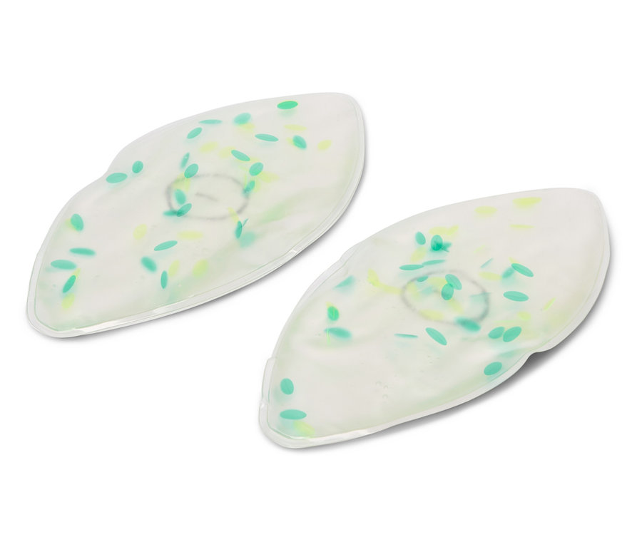 Dwie białe żelowe maski na oczy z zielonymi i żółtymi kropkami leżą na białym tle.