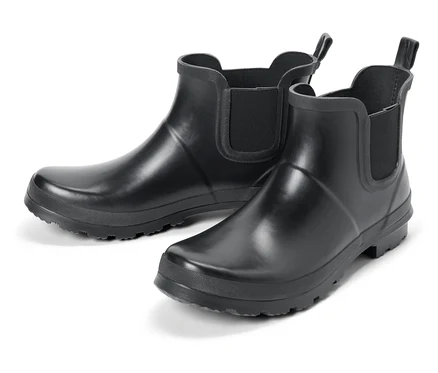 Dwa czarne gumowe buty na białym tle.