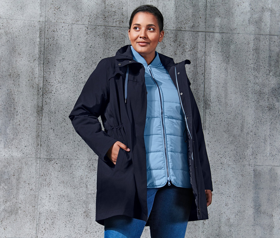 Kobieta pozuje w niebieskim płaszczu trekkingowym 3 w 1.