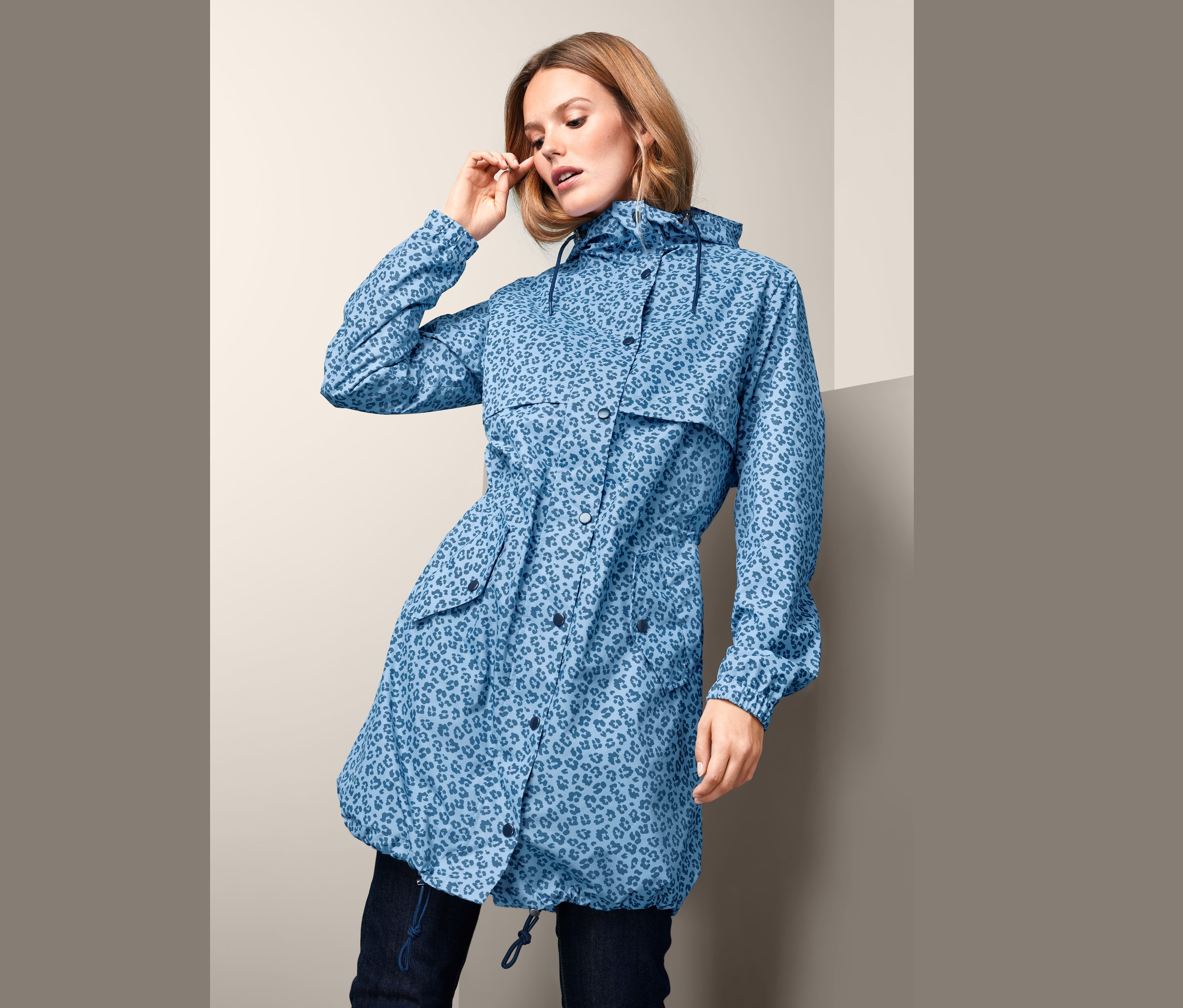 Kobieta ma na sobie niebieski płaszcz przeciwdeszczowy w lamparcie cętki.