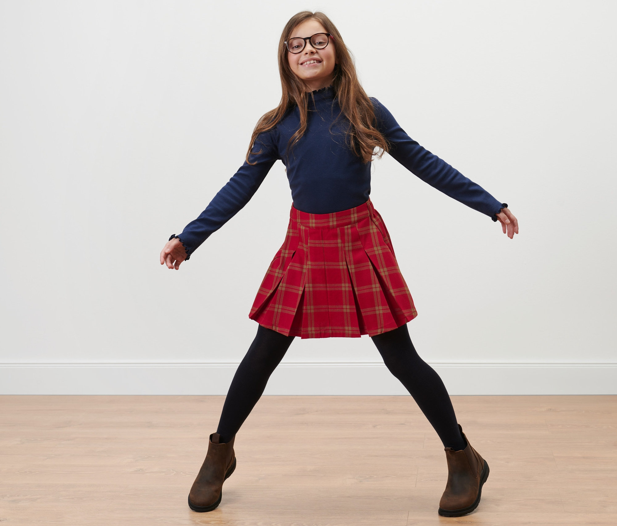 Dziewczynka pozuje w spódnico-spodniach dziecięcych.