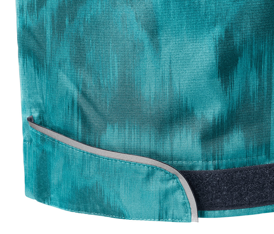 Zbliżenie na spodnie przeciwdeszczowe z nadrukiem, elementami odblaskowymi i zapięciem na rzep.