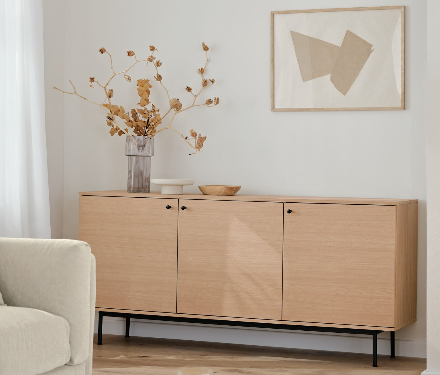 Salon z szafką typu sideboard »Finnsbo«, szafką typu highboard »Finnsbo« i czarną lampą stołową ze szklaną kulą.